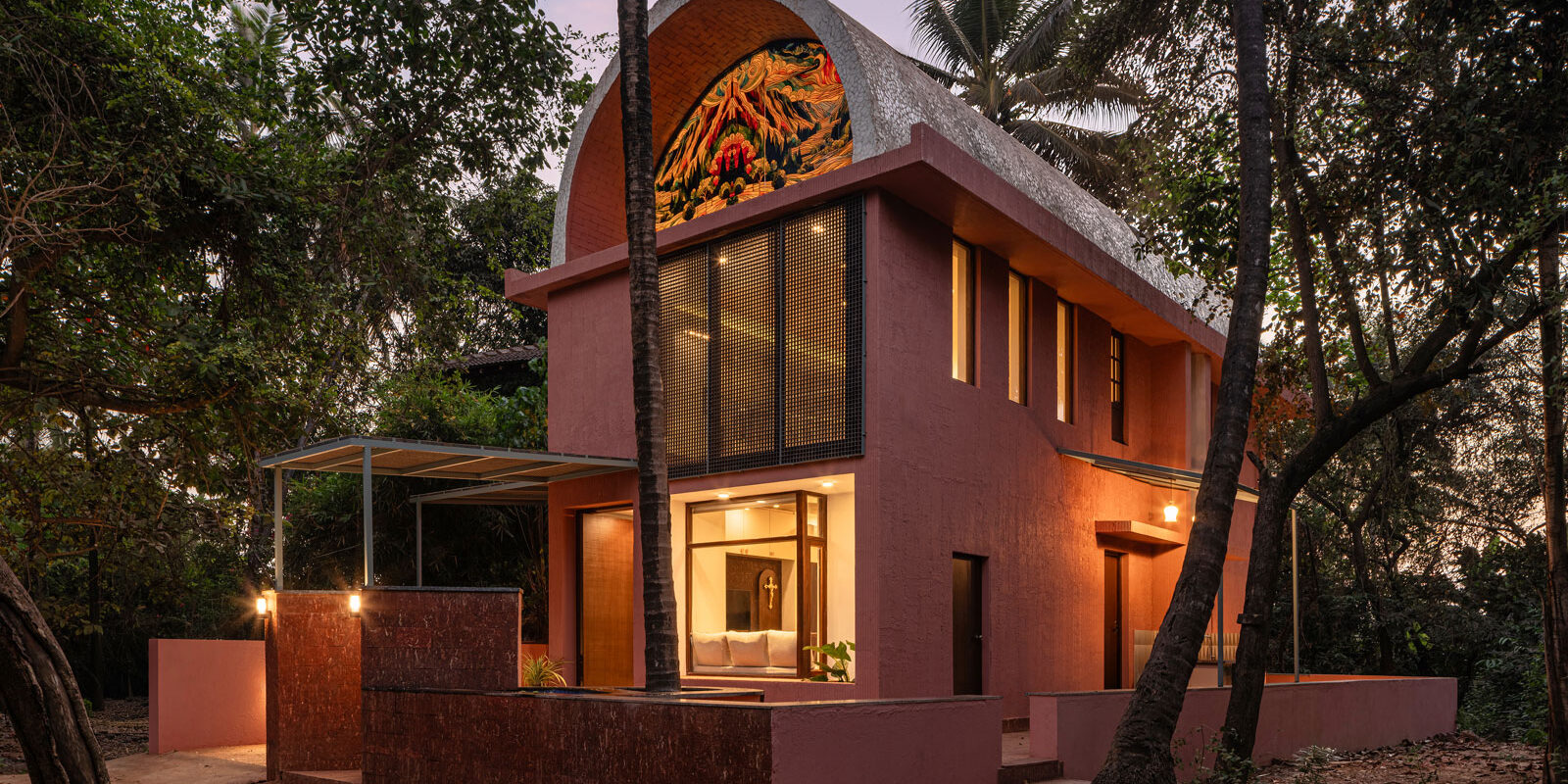 facade view by night of the vaulted roof house in goa designed by 19dotarchitects