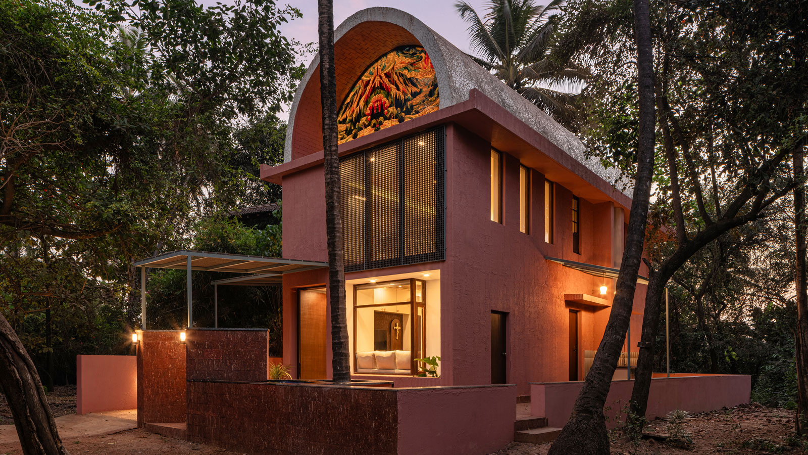 facade view by night of the vaulted roof house in goa designed by 19dotarchitects