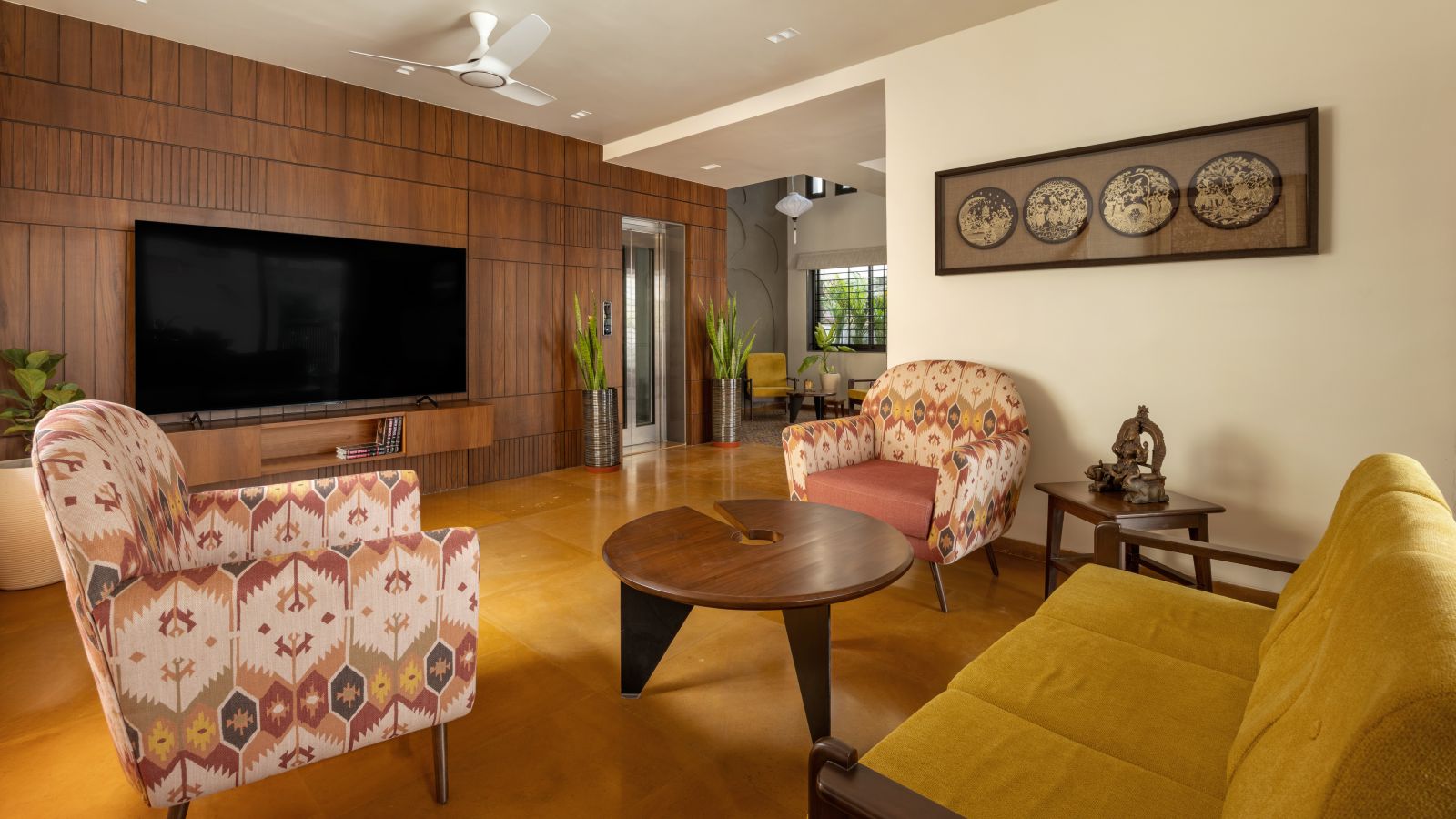 living room at nirhans bungalow vadodara where the staircase acts as the climatic spine. designed by studio yamini architects